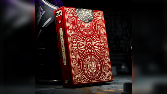 Obey Red Edition playing cards by theory11 limited art collector deck tuck case with intricate red and gold design displayed on a dark studio background