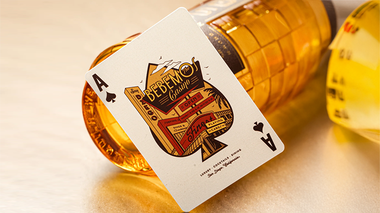 Bebemos Casino playing cards by theory11 featuring the Ace of Spades card leaning against a tequila bottle in warm golden bar lighting with retro casino artwork
