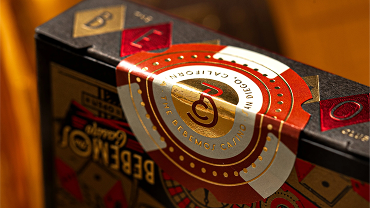Bebemos Casino playing cards by theory11 featuring gold foil seal and retro casino tuck case design in warm bar lighting