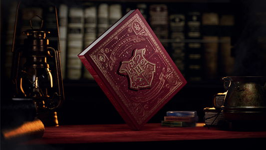 Harry Potter playing cards box set by theory11 featuring a red Hogwarts-themed collector book box displayed on a wooden table with lantern and books.