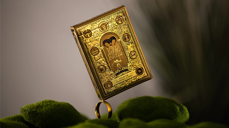 Lord of the Rings playing cards box set by theory11 with gold embossed Middle-earth design displayed on moss