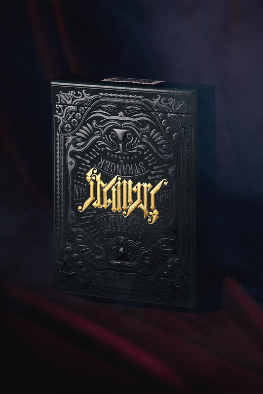 Ultimate Deck by Art of Play luxury playing cards with black and gold ornate tuck box on a dark atmospheric background